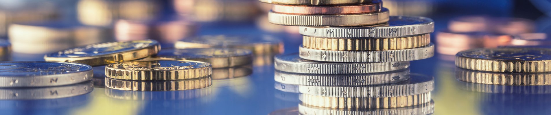 Tower with euro coins and flag of European Union in the background.