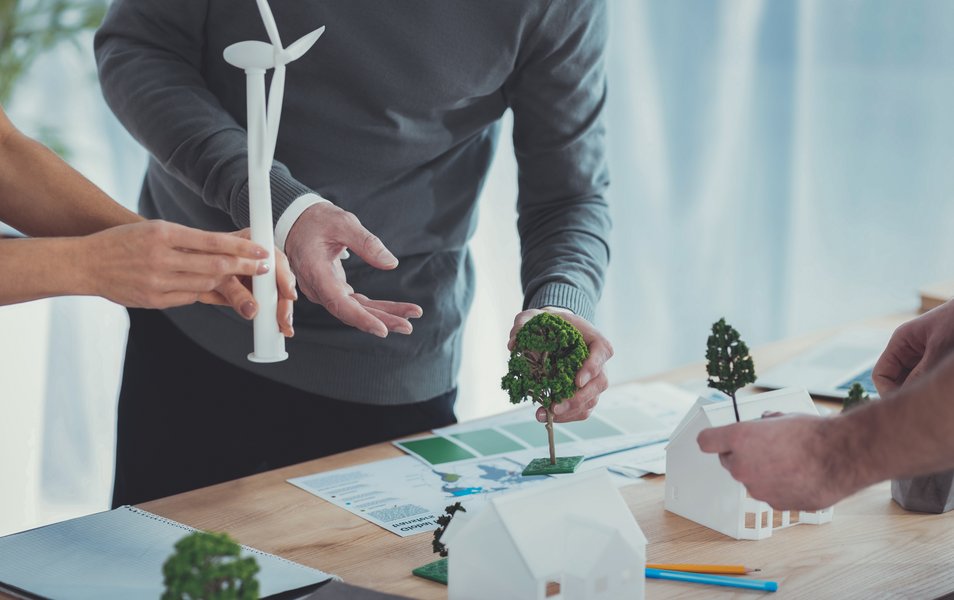 General planning. Close up of male and female hands carrying models and arranging them on surface