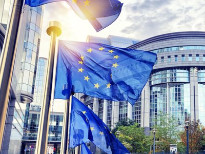 EU flags waving in front of European Parliament building. Brussels, Belgium