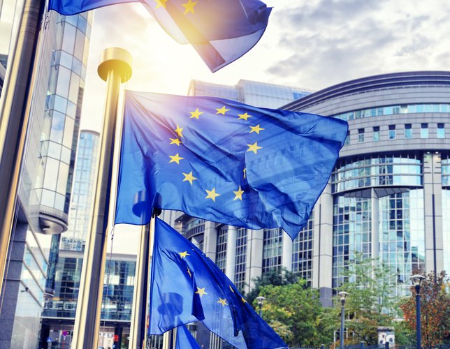 EU flags waving in front of European Parliament building. Brussels, Belgium