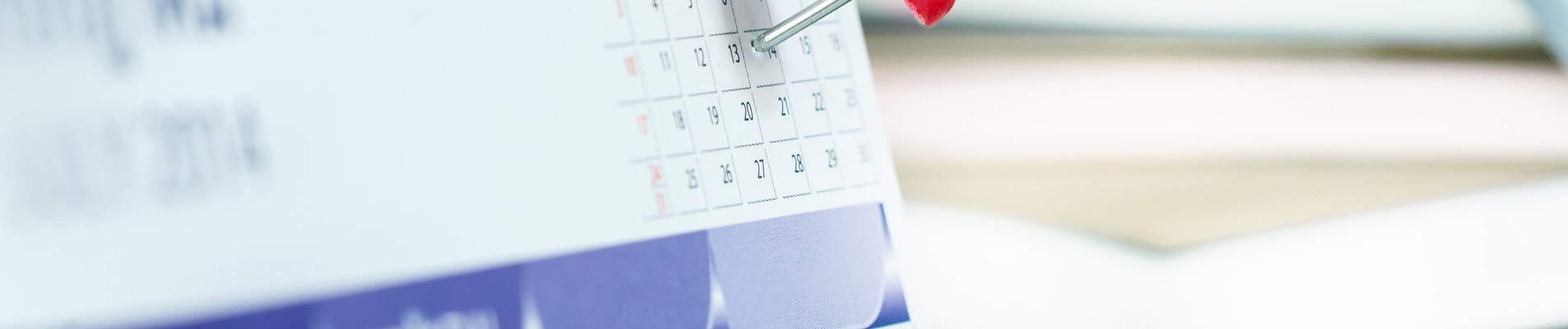 Red pushpin on calendar page for remind and marked important events